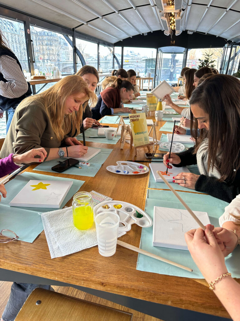 Equipe marketing en plein teambuilding autour d'une peinture collaborative